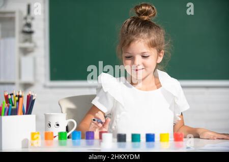 Les petites filles dessinant des images colorées avec des crayons de couleur dans la salle de classe de l'école.Peindre les enfants.Un petit artiste drôle de peinture, dessin art. Banque D'Images