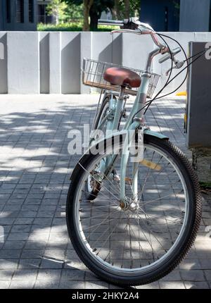 Vue de face d'un vélo bleu d'époque avec panier garé près de l'hôtel, service pour les clients, client du complexe, style vertical. Banque D'Images