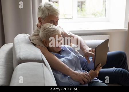Couple de famille mûre d'âge moyen heureux utilisant le gadget numérique Banque D'Images