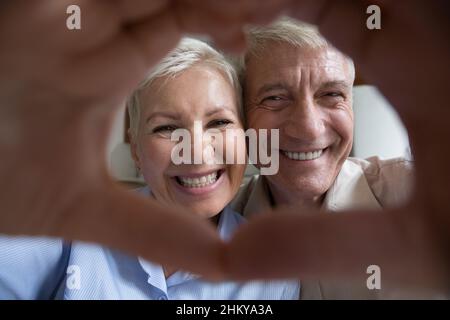 Portrait de couple aîné mûr heureux avec cadre en forme de coeur de main Banque D'Images