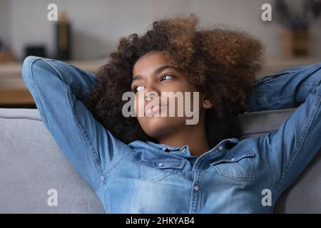 Jeune fille noire attentionnés avec un coiffo Afro reposant sur un canapé Banque D'Images