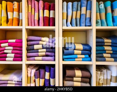 Tissus de différentes couleurs sur une étagère avec de nombreux compartiments dans une boutique de tissus Banque D'Images