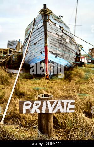 Panneau « privé » peint à la main devant un vieux bateau en bois Banque D'Images