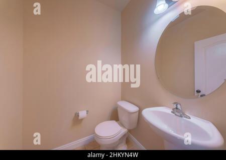 Petite salle de bains intérieure avec murs beige et lavabo sur pied Banque D'Images