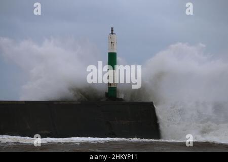 Aberystwyth pays de Galles Royaume-Uni météo Febuary 6th 2022 .De grandes vagues se brisent dans et au-dessus de la lumière du port et de la promenade lors d'une froide journée d'hiver sur la côte ouest de la grande-bretagne, de forts vents avec un refroidissement mordant entraînent les vagues géantes à marée haute, ce qui peut endommager les structures et les biens.Crédit : mike davies/Alamy Live News Banque D'Images