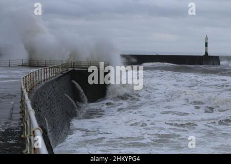 Aberystwyth pays de Galles Royaume-Uni météo Febuary 6th 2022 .De grandes vagues se brisent dans et au-dessus de la lumière du port et de la promenade lors d'une froide journée d'hiver sur la côte ouest de la grande-bretagne, de forts vents avec un refroidissement mordant entraînent les vagues géantes à marée haute, ce qui peut endommager les structures et les biens.Crédit : mike davies/Alamy Live News Banque D'Images