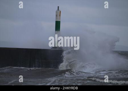 Aberystwyth pays de Galles Royaume-Uni météo Febuary 6th 2022 .De grandes vagues se brisent dans et au-dessus de la lumière du port et de la promenade lors d'une froide journée d'hiver sur la côte ouest de la grande-bretagne, de forts vents avec un refroidissement mordant entraînent les vagues géantes à marée haute, ce qui peut endommager les structures et les biens.Crédit : mike davies/Alamy Live News Banque D'Images