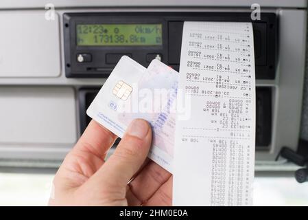 Gros plan d'un conducteur tenant un quart de jour imprimé en vue avec le permis de conduire et la carte tachygraphe numérique . Banque D'Images