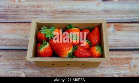 Gros plan de fraises biologiques juteuses dans une boîte en carton écologique. Banque D'Images