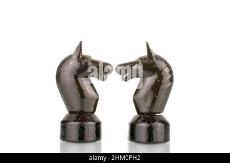 Deux vieilles pièces d'échecs en bois en noir, macro, isolées sur fond blanc. Banque D'Images
