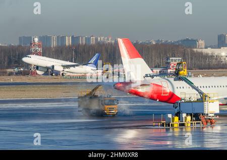 Dégivrage de l'aile de l'avion avant le vol.Hiver givré jour à l'aéroport, et un avion de décollage en arrière-plan Banque D'Images