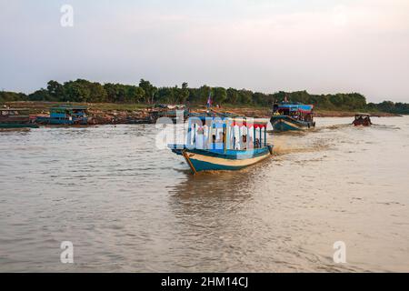 Siem Reap, Cambodge - février, 2013: Les touristes sur les bateaux à moteur vont voir le village flottant sur le lac Tonle SAP Banque D'Images