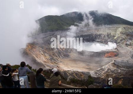 POAs, Costa Rica; 08032007: Vue aérienne du volcan Poas.Groupe de touristes regardant son cratère alors que la fumée sort. Banque D'Images