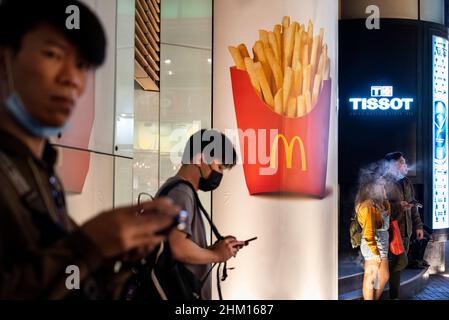 Hong Kong, Chine.23rd janvier 2022.Les gens se tiennent à l'extérieur près d'une publicité commerciale McDonald's présentant des frites à Hong Kong.(Credit image: © Budrul Chukrut/SOPA Images via ZUMA Press Wire) Banque D'Images