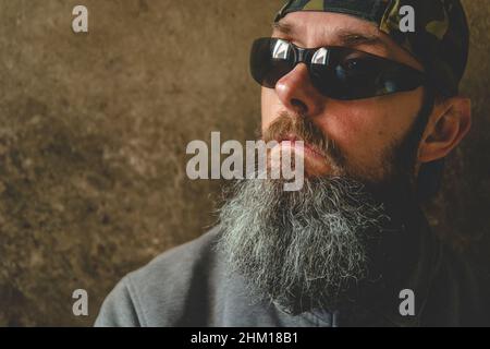 Un homme avec une longue barbe portant des lunettes de soleil, portrait Banque D'Images