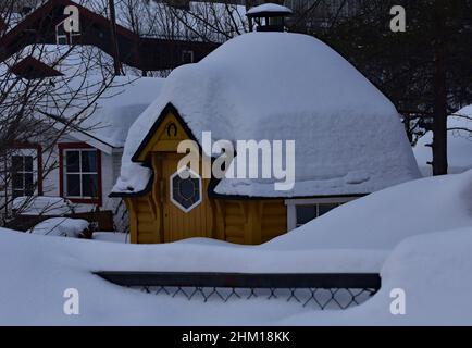 La « maison d'hiver » en bois s'est transformée en « maison d'hiver » par les profondeurs enneigées d'un hiver norvégien rigoureux dans la petite ville de Kirkenes, dans le nord-est de la Norvège. Banque D'Images