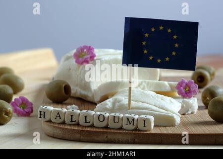 Fromage traditionnel appelé Made in Cyprus, mot HALLOUMI fait de letteurs en bois cubes, drapeau de l'UE, olives et fleurs roses Banque D'Images