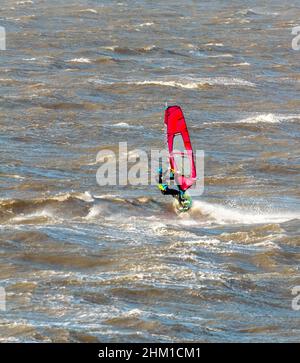 Surfeur sur les vagues en hiver à Gullane Beach, East Lothian en Écosse, Royaume-Uni Banque D'Images