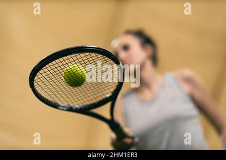 Une joueuse de tennis tient la raquette et le ballon sur le court.Vue de dessous Banque D'Images