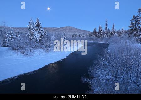 Rivière Yaak et lune à l'aube en hiver. Vallée de Yaak, nord-ouest du Montana. (Photo de Randy Beacham) Banque D'Images