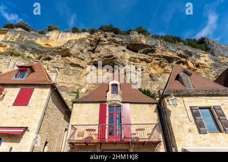 Falaise de calcaire et maisons historiques en pierres jaunes de la Roque-Gageac, Périgord, prises pendant un après-midi d'automne ensoleillé Banque D'Images