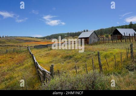 Un vieux ranch avec des clôtures et des bâtiments de ferme en bois rustique dans le Colorado.Une scène d'automne sous un ciel bleu. Banque D'Images