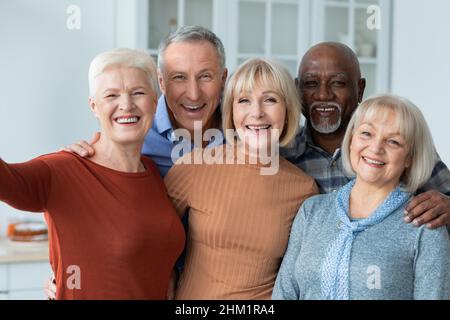 Des personnes âgées positives qui se rassemblent autour du selfie, à l'intérieur de la cuisine Banque D'Images