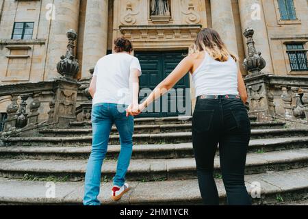 Un jeune couple monter les escaliers tout en saisissant les mains un bâtiment ancien Banque D'Images