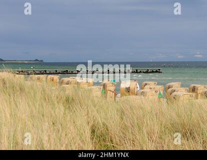 Chaises de plage en osier sur la plage de Burg sur l'île de Fehmarn Allemagne lors D'Une belle journée ensoleillée d'été avec Un ciel bleu clair et quelques nuages Banque D'Images