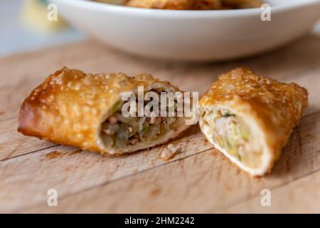 Des rouleaux de printemps frits et croustillants faits maison montrant les garnitures de légumes et de viande à l'intérieur. Banque D'Images