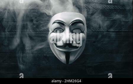 Studio photo d'un masque de Vendetta anonyme avec fumée sur bois Banque D'Images