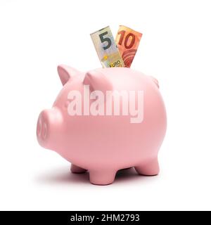 Piggy Bank avec une note de 5 et 10 euros sur blanc Banque D'Images
