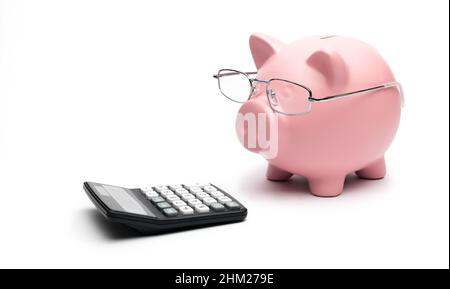 Piggy Bank avec calculatrice sur fond blanc Banque D'Images