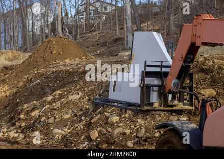 Une cuisine en granit étant soulevée par un chariot élévateur avec chantier de construction Banque D'Images