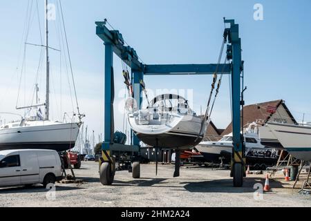 Un yacht est transporté à travers Largs Marina, dans le nord de l'Ayrshire, en Écosse, sur un pont-bateau. Banque D'Images