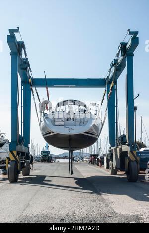 Un yacht est transporté à travers Largs Marina, dans le nord de l'Ayrshire, en Écosse, sur un pont-bateau. Banque D'Images