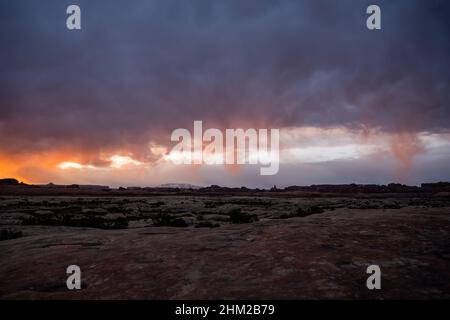 Le soleil du matin met en évidence des nuages de basse pluie au-dessus du quartier des aiguilles des Canyonlands Banque D'Images