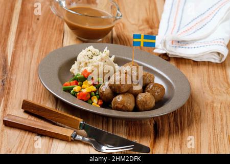 Meatball suédois avec sauce brune aux champignons et légumes durs, servi avec une purée de pommes de terre crémeuse.Sur une table en bois Banque D'Images