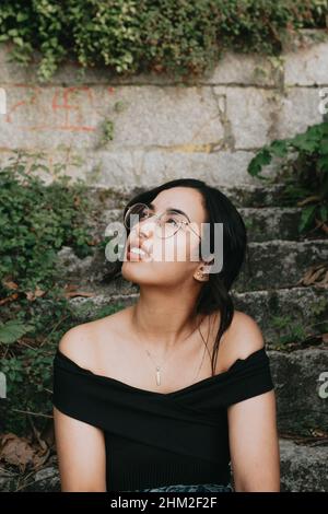 Jeune belle femme africaine regardant loin de l'appareil photo sur des vêtements et des lunettes de printemps Banque D'Images