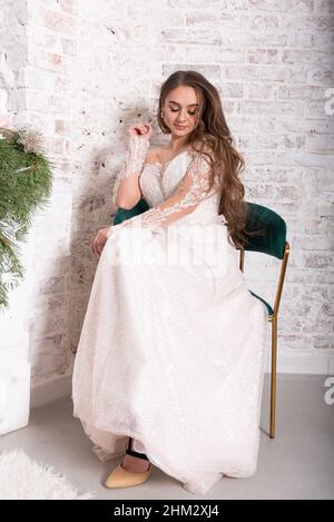 La mariée dans une robe blanche est assise sur une chaise.Photo de haute qualité Banque D'Images