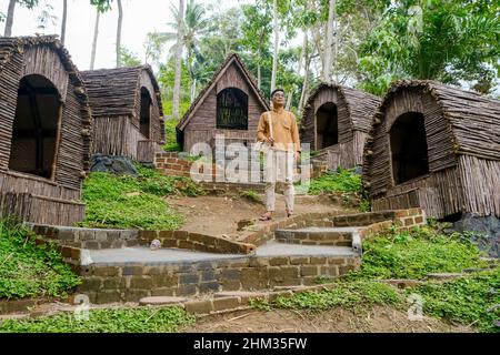 Lampung, Indonésie, février 02 2022- Un homme se tient devant l'aménagement de maisons artisanales locales dans un parc de tourisme naturel à Lampung, Banque D'Images