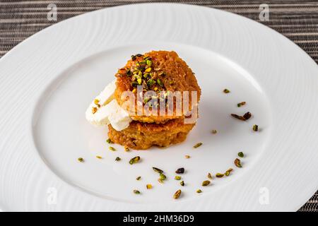 Un kadayif de pain ou un Kadayifi d'Ekmek accompagné de crème, un délicieux dessert turc servi dans un restaurant gastronomique Banque D'Images