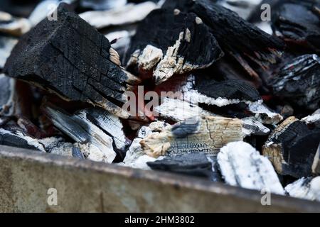 Charbons lumineux dans un barbecue rouillé.Vue en diagonale depuis l'avant.Répétition. Banque D'Images