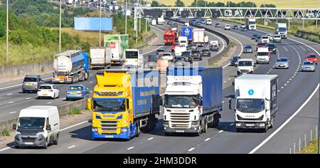 Camion de transport quatre voies de l'autoroute M25 Essex Countryside camionnette blanche dépasse les camions et camions hgv plus lents trafic occupé sur gradient Angleterre Royaume-Uni Banque D'Images