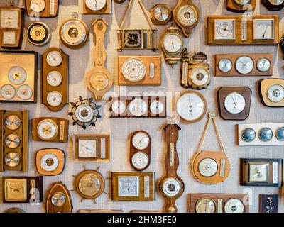 collection de vieux baromètres rétro et de montres accrochées à un mur texturé Banque D'Images