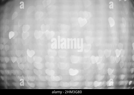 Arrière-plan de lumières en forme de cœur, blanches et floues Banque D'Images