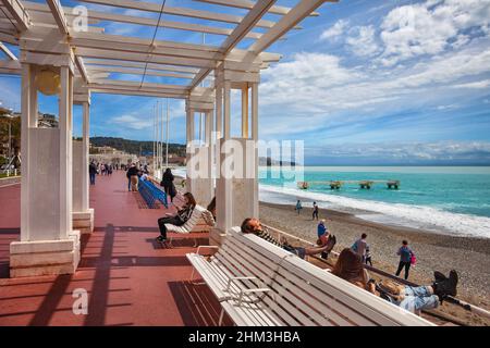 Nice, France - 13 avril 2018 : personnes sur la populaire Promenade des Anglais et la plage sur la Côte d'Azur par la mer Méditerranée par beau temps. Banque D'Images