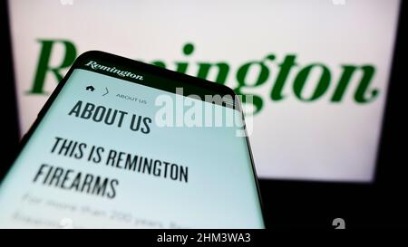 Smartphone avec la page Web de la société américaine RemArms LLC (Remington Arms) à l'écran devant le logo de l'entreprise. Faites la mise au point dans le coin supérieur gauche de l'écran du téléphone. Banque D'Images