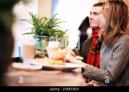 Heureux couple eating fast food burger et döner dans fast food cafe Banque D'Images