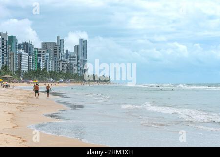 Paysage d'une belle plage brésilienne du nord-est, les gens marchant sur la plage, les baigneurs sur l'eau et la ville sur fond.Boa Viagem être Banque D'Images